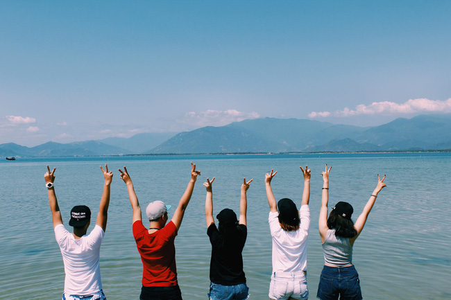 Đứng quay lưng nhìn cảnh, dơ 2 tay